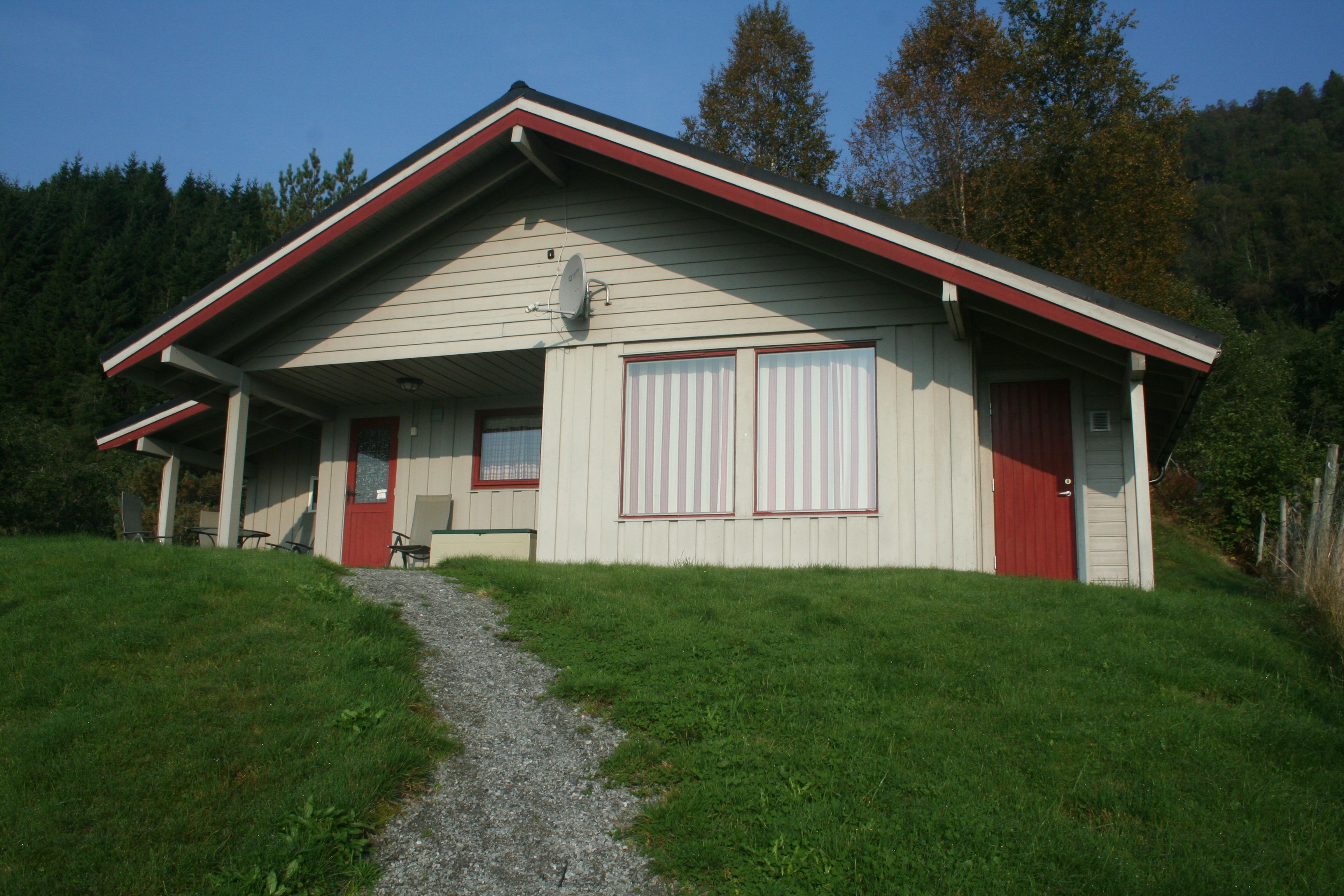 Sjusete Cabins – cozy timber cabin with red accents, surrounded by Norwegian nature.