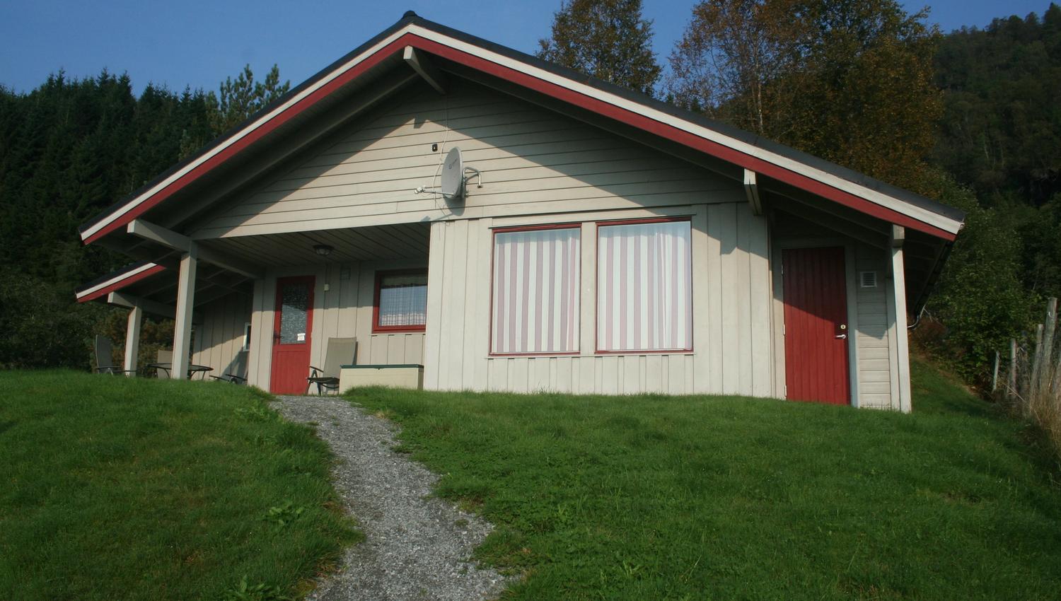 Sjusete Cabins – cozy timber cabin with red accents, surrounded by Norwegian nature.