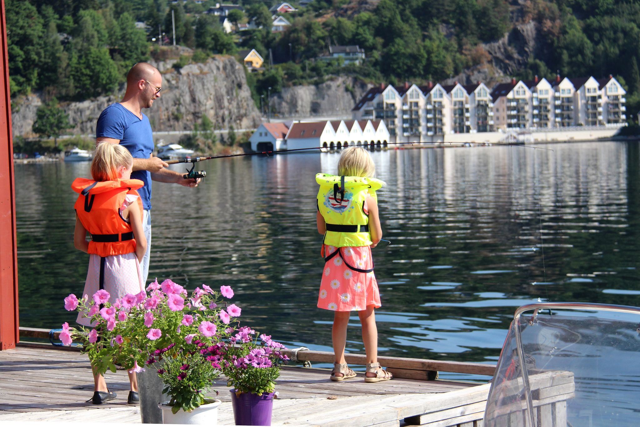 Familie fisker fra brygge hos Bjørn Ottersen leiligheter.