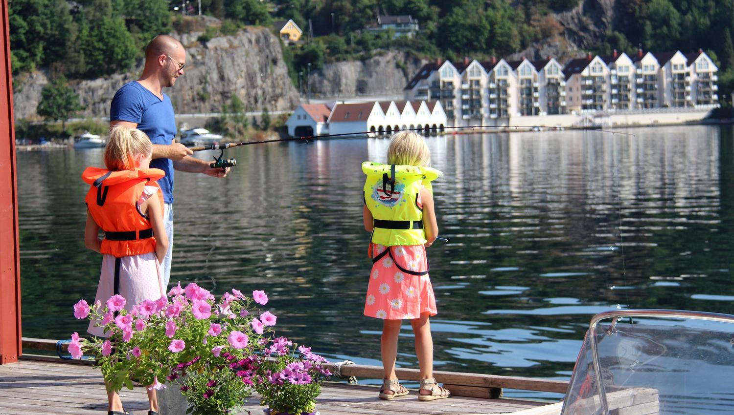 Familie fisker fra brygge hos Bjørn Ottersen leiligheter.