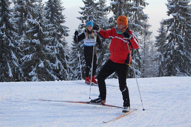 Instructor observing a man skiing