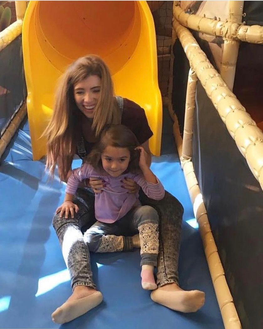 Child and woman on their way out of the tunnel slide