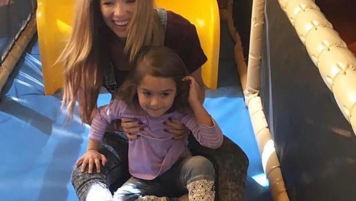 Child and woman on their way out of the tunnel slide
