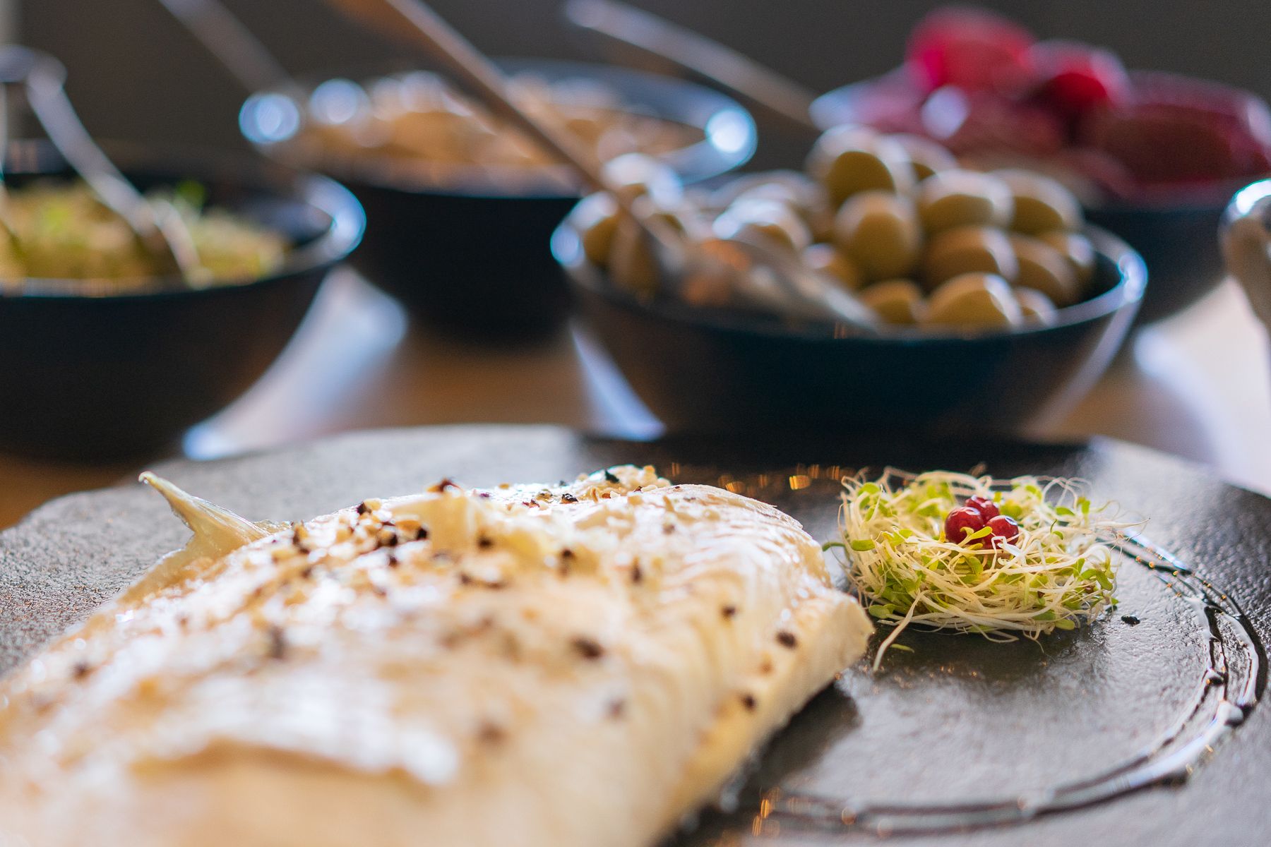 White fish presented on a slate with accompaniments