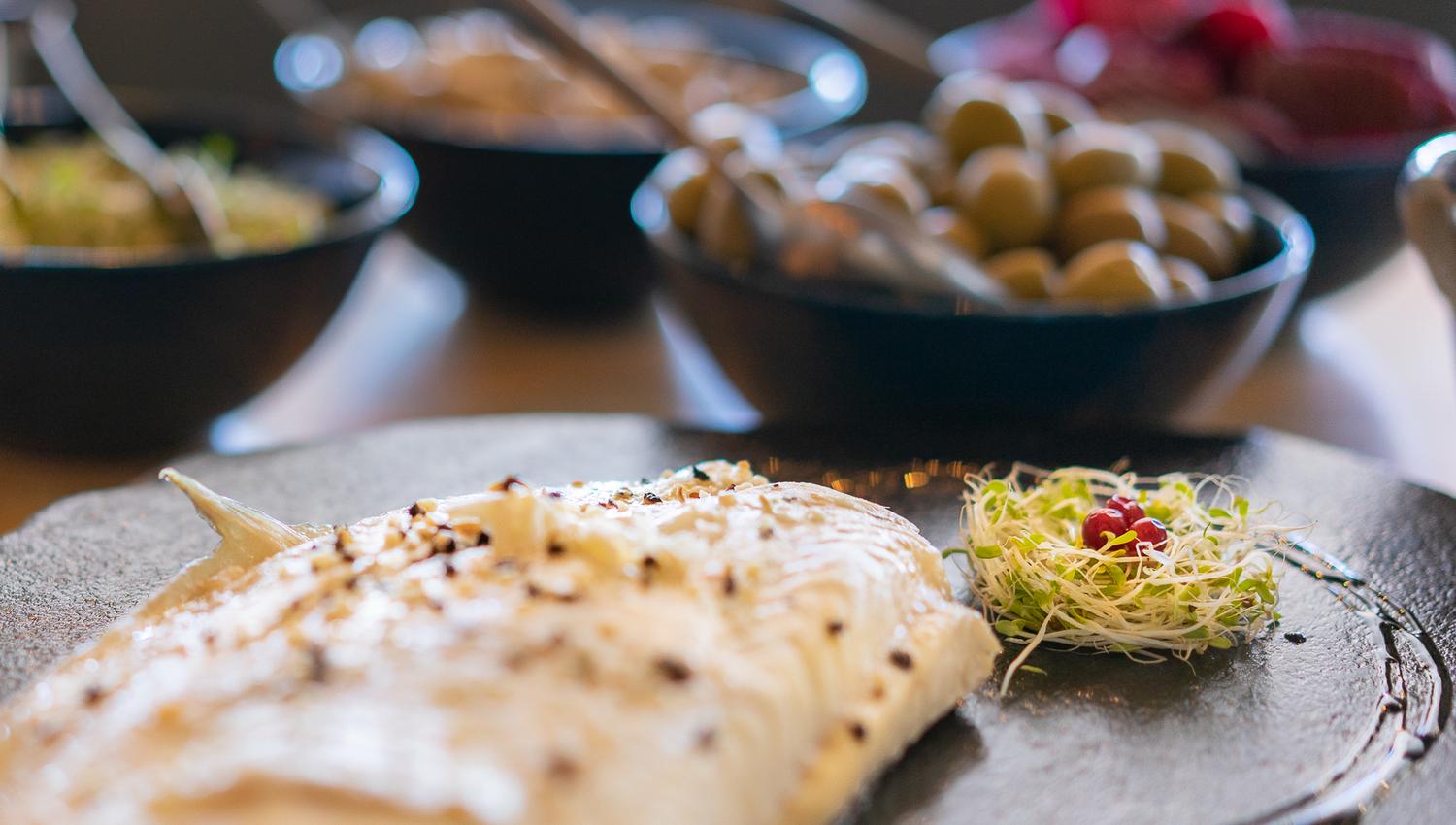 White fish presented on a slate with accompaniments