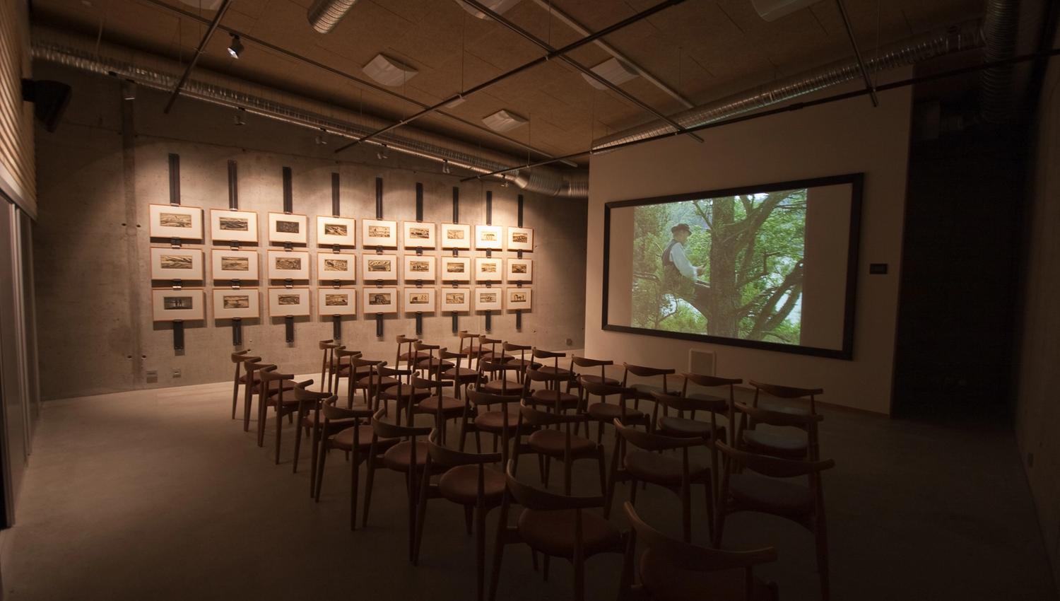 Room with many chairs facing a large screen