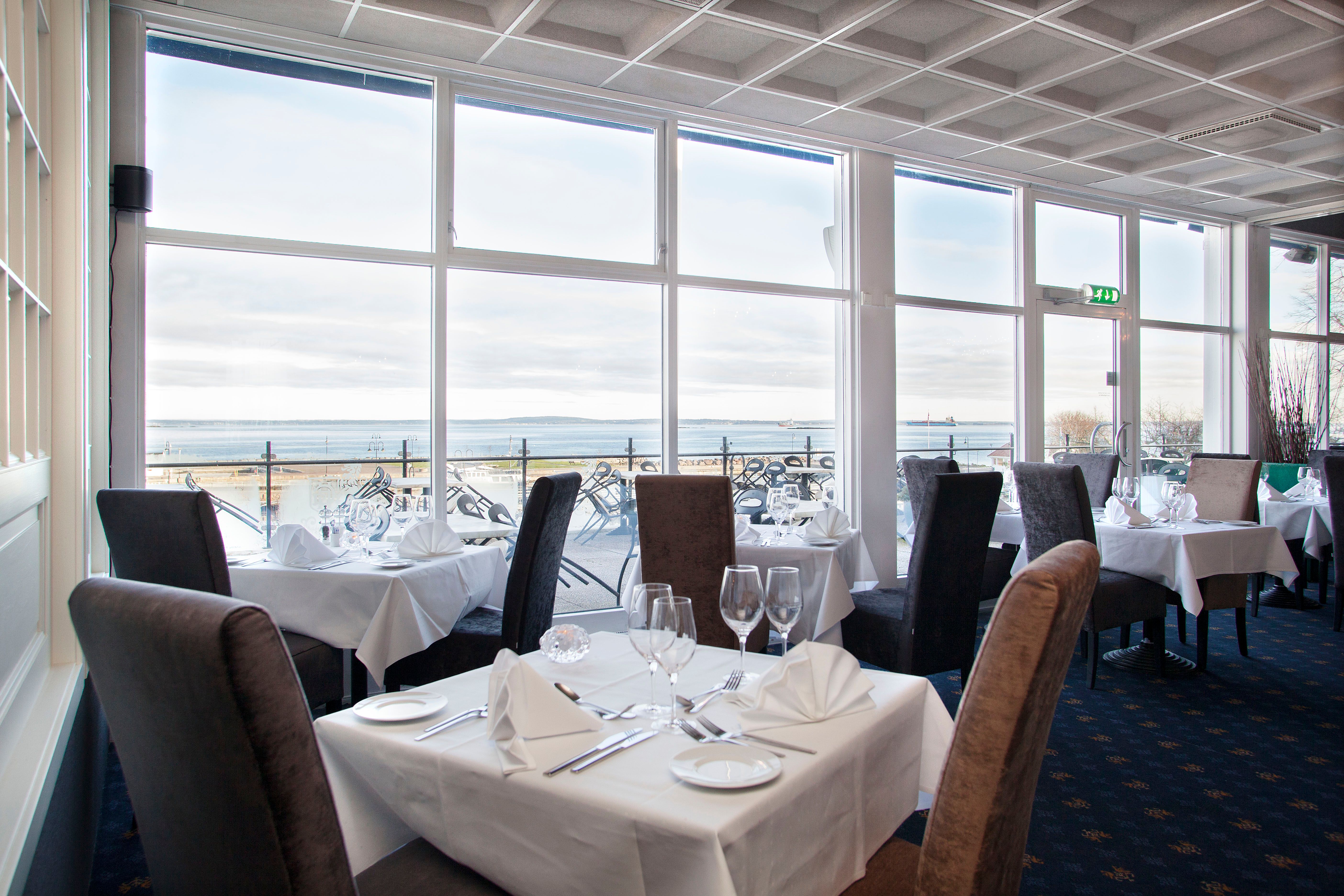 Restaurant with set table and chairs, with a view over the water