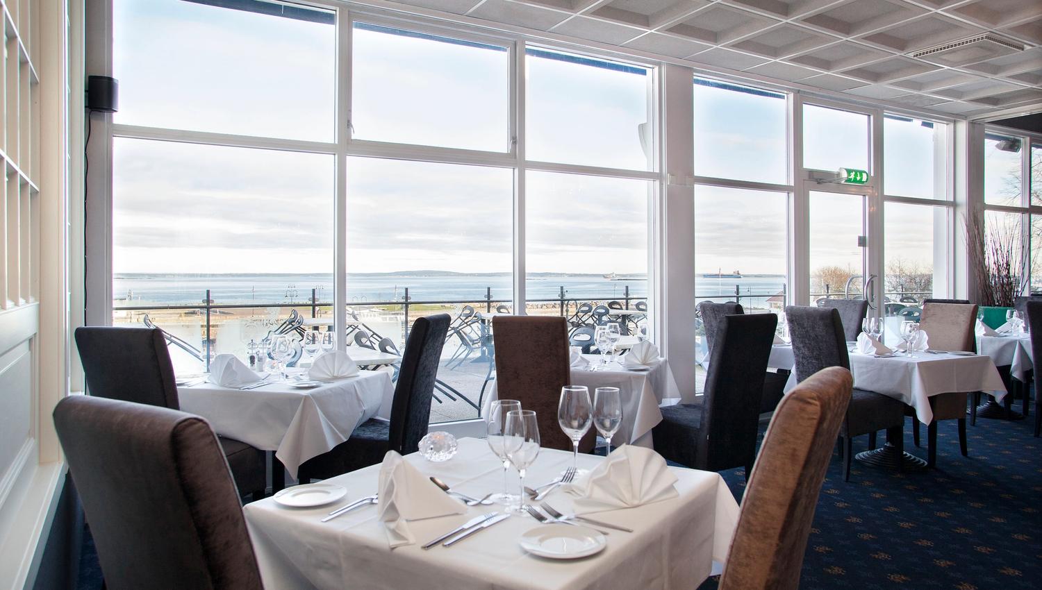 Restaurant with set table and chairs, with a view over the water