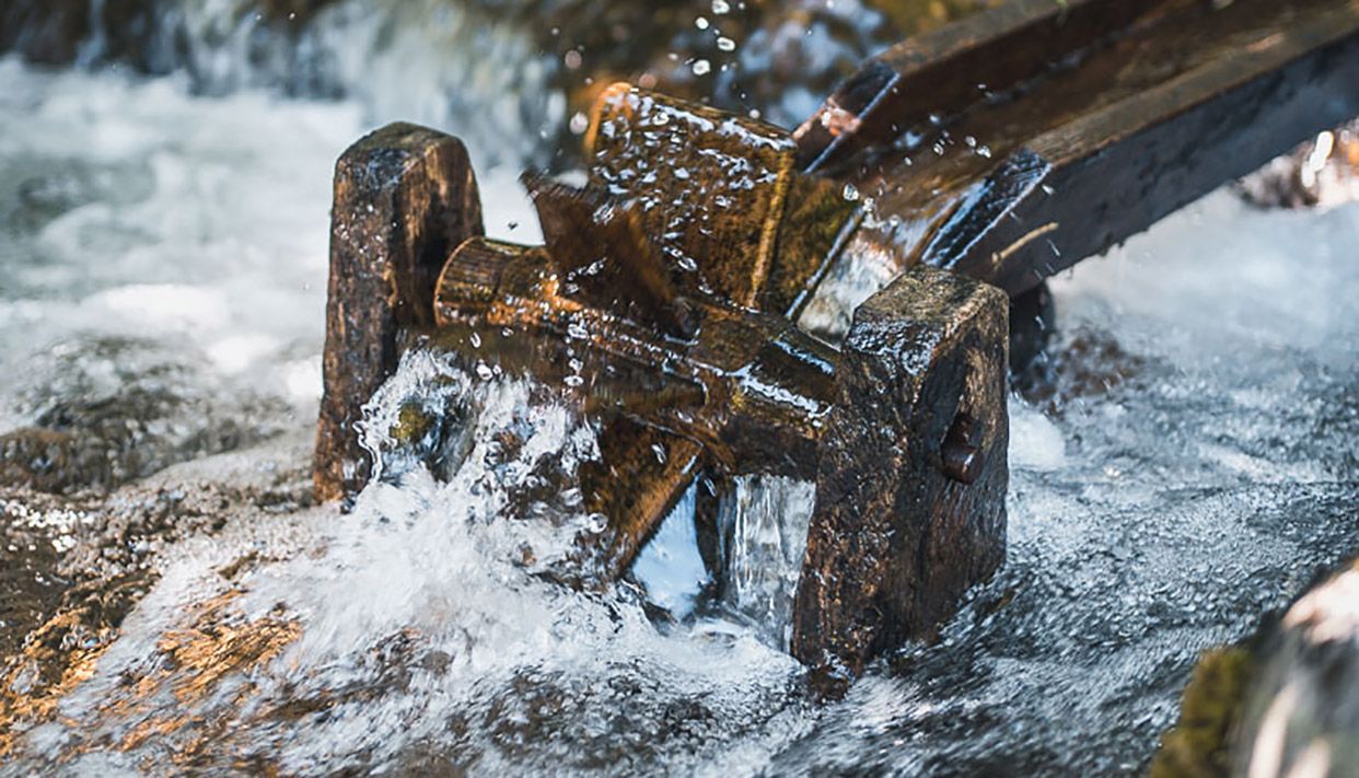 Waterwheel in a stream at Steinparken Rosendal, a playful and educational feature for children.