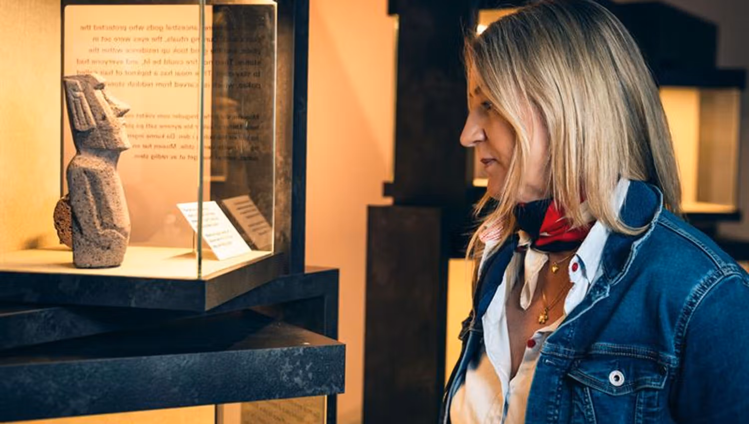 Woman looking at a mini sculpture from Easter Island