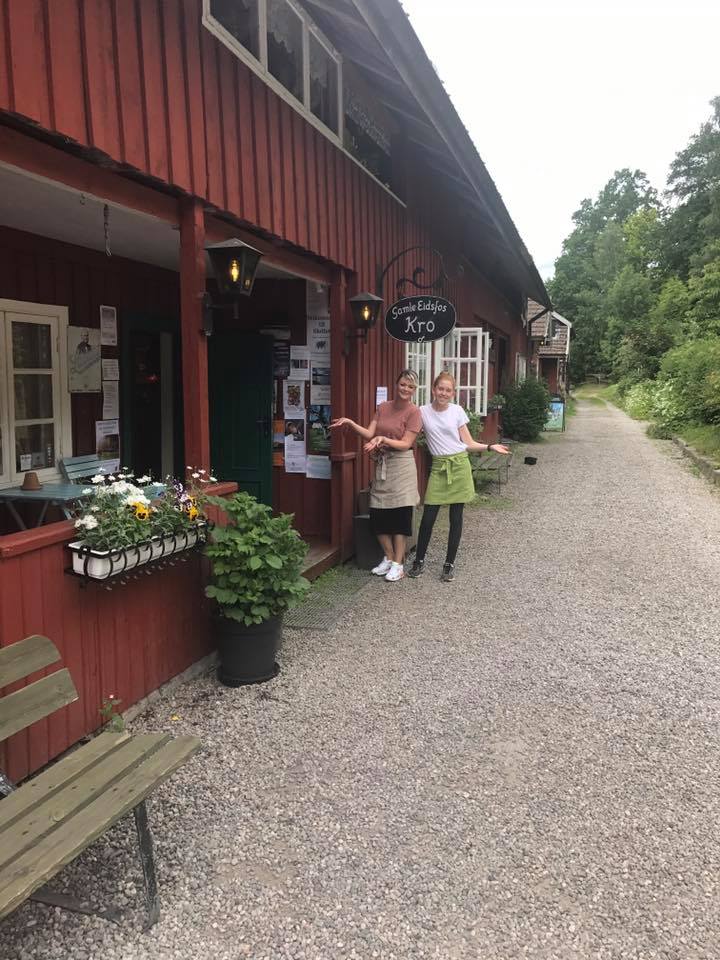 Two smiling employees outside the tavern