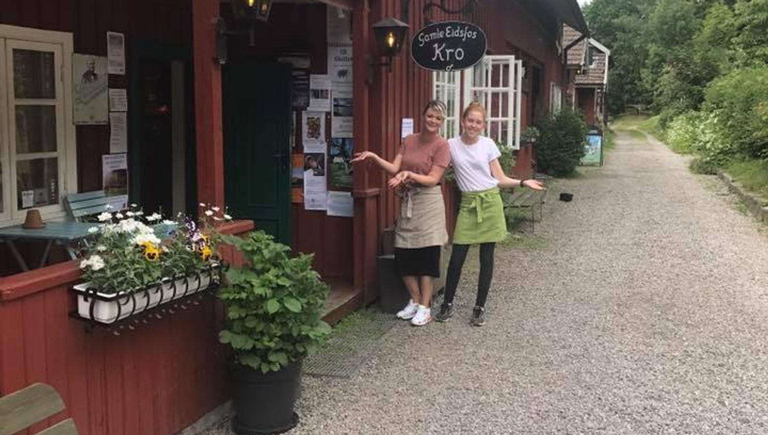 Two smiling employees outside the tavern