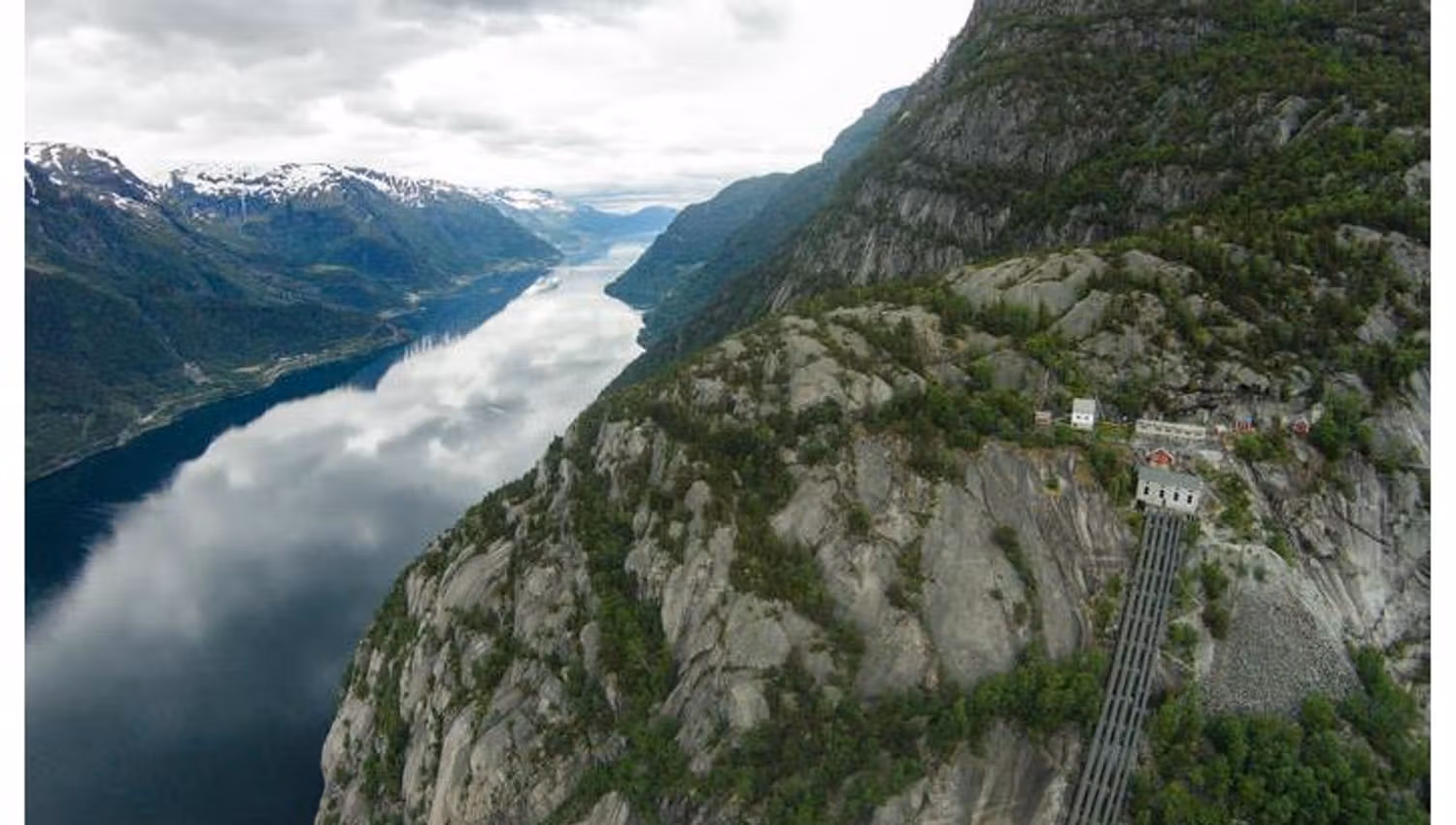 Aerial view of Lilletopp, showcasing the steep mountainsides and the iconic pipeline leading to the fjord.