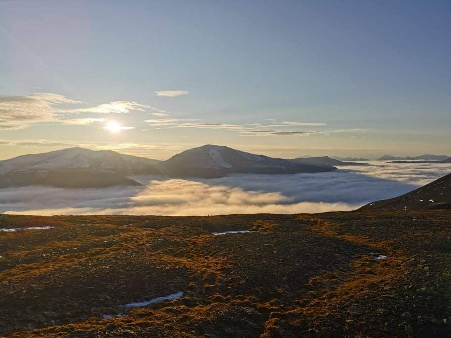 Utsikt fra et fjell med tåke i bunn av dalen