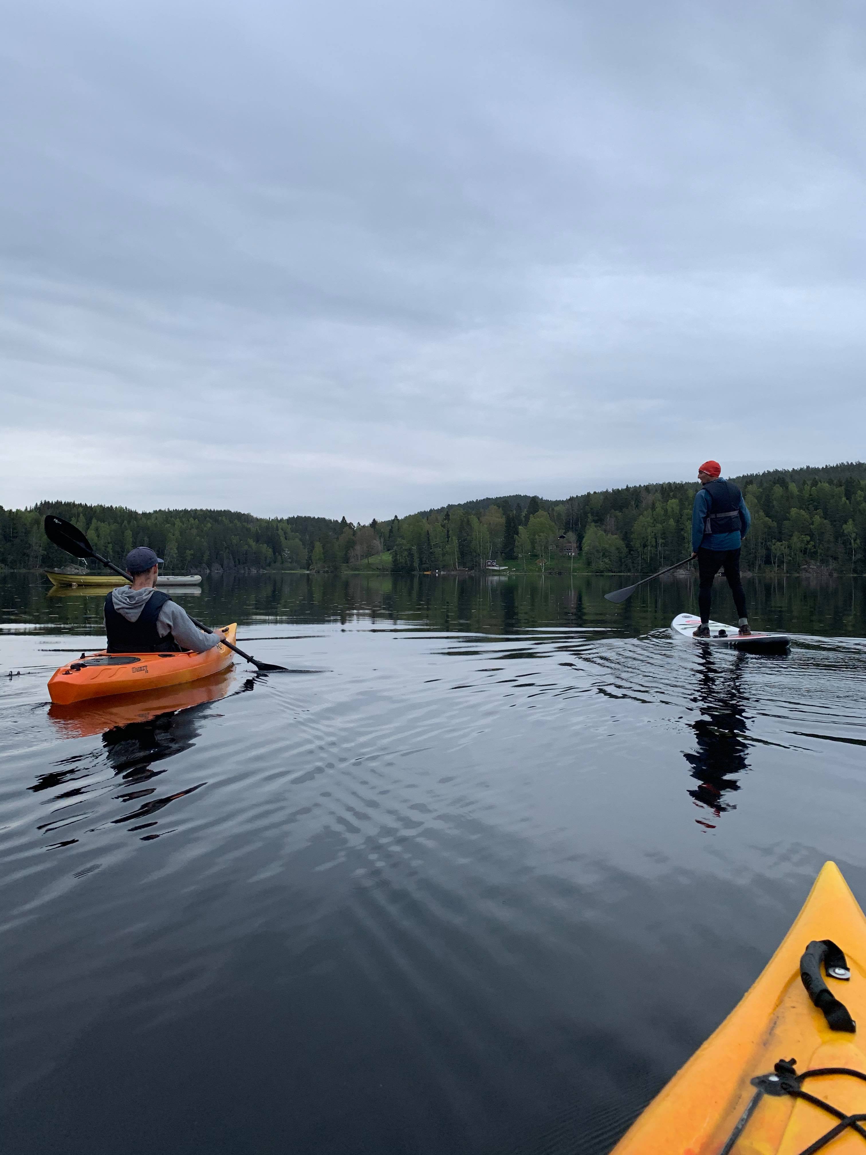 2 kayaks and one padling on a sup