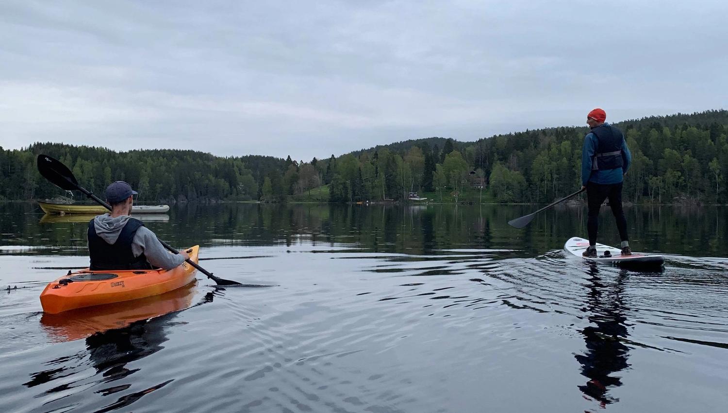 2 kayaks and one padling on a sup