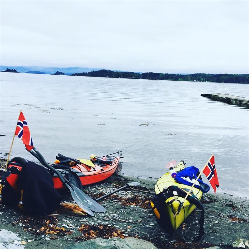 To kajakker med norske flagg på en strand