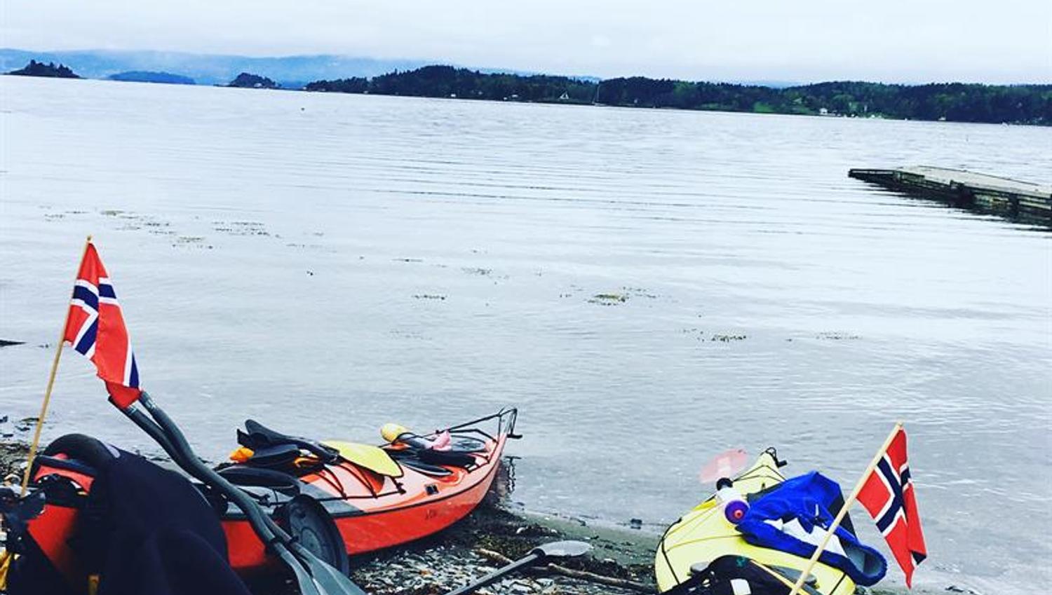 To kajakker med norske flagg på en strand