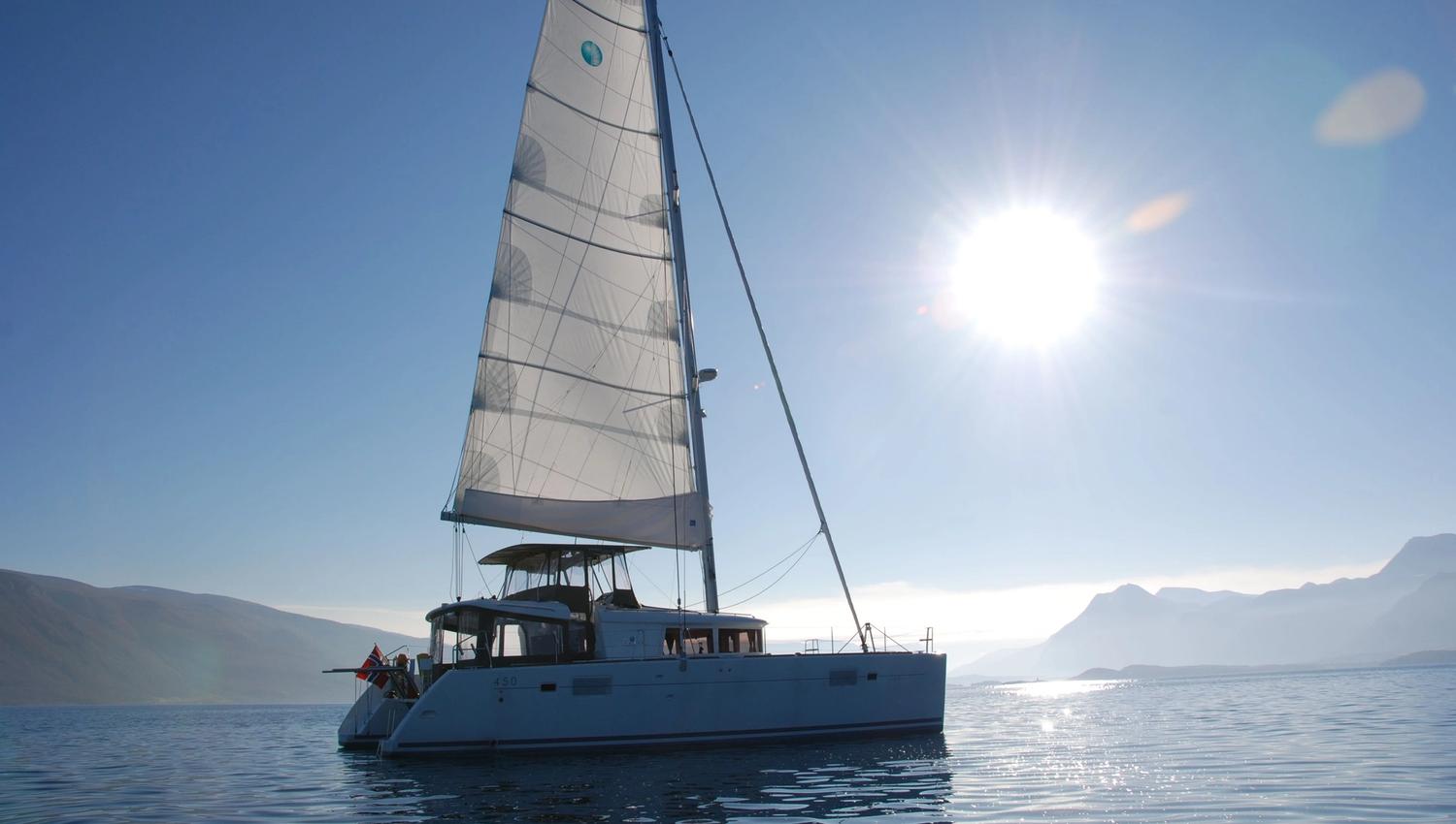 The sailing boat cruising beneath a beautiful sunset