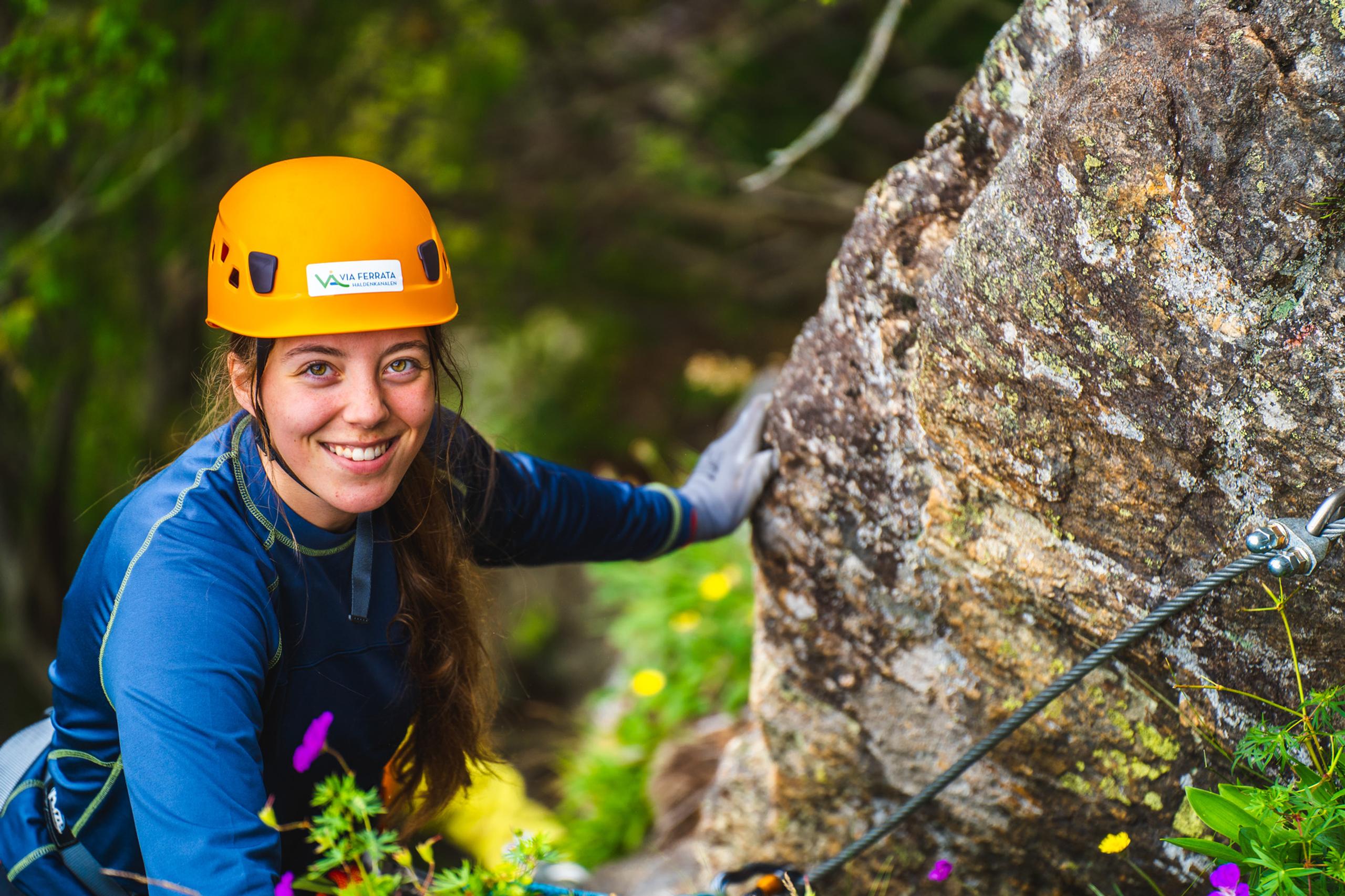 Jente i klatreløypa på vei opp fjellet i Via ferrata Haldenkanalen