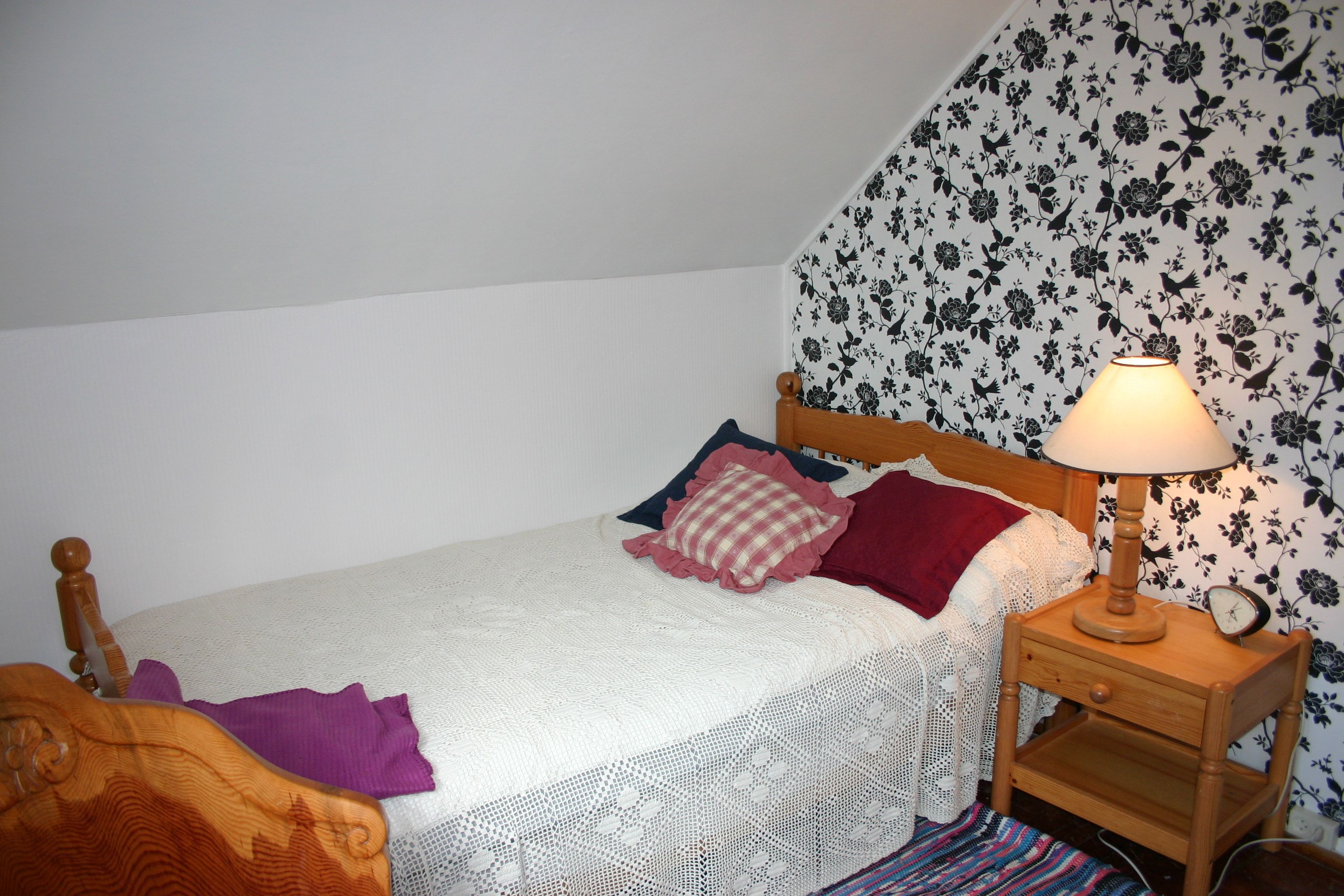 Cozy bedroom with decorative wallpaper at Hardanger Harmoni Fjordhus.