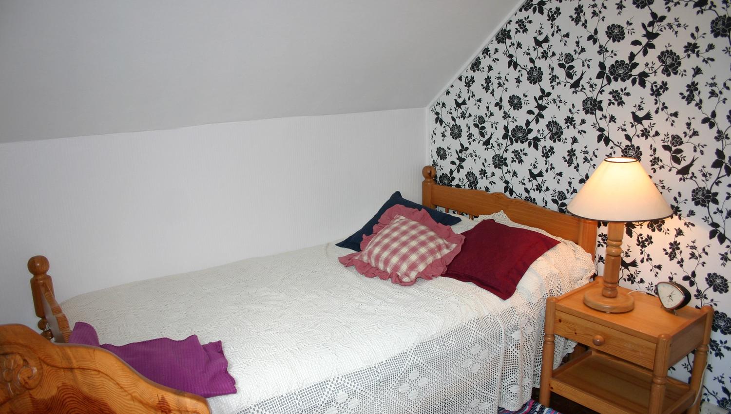 Cozy bedroom with decorative wallpaper at Hardanger Harmoni Fjordhus.