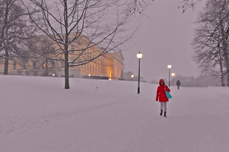 The Palace during snowy weather. Lady in red walking by.