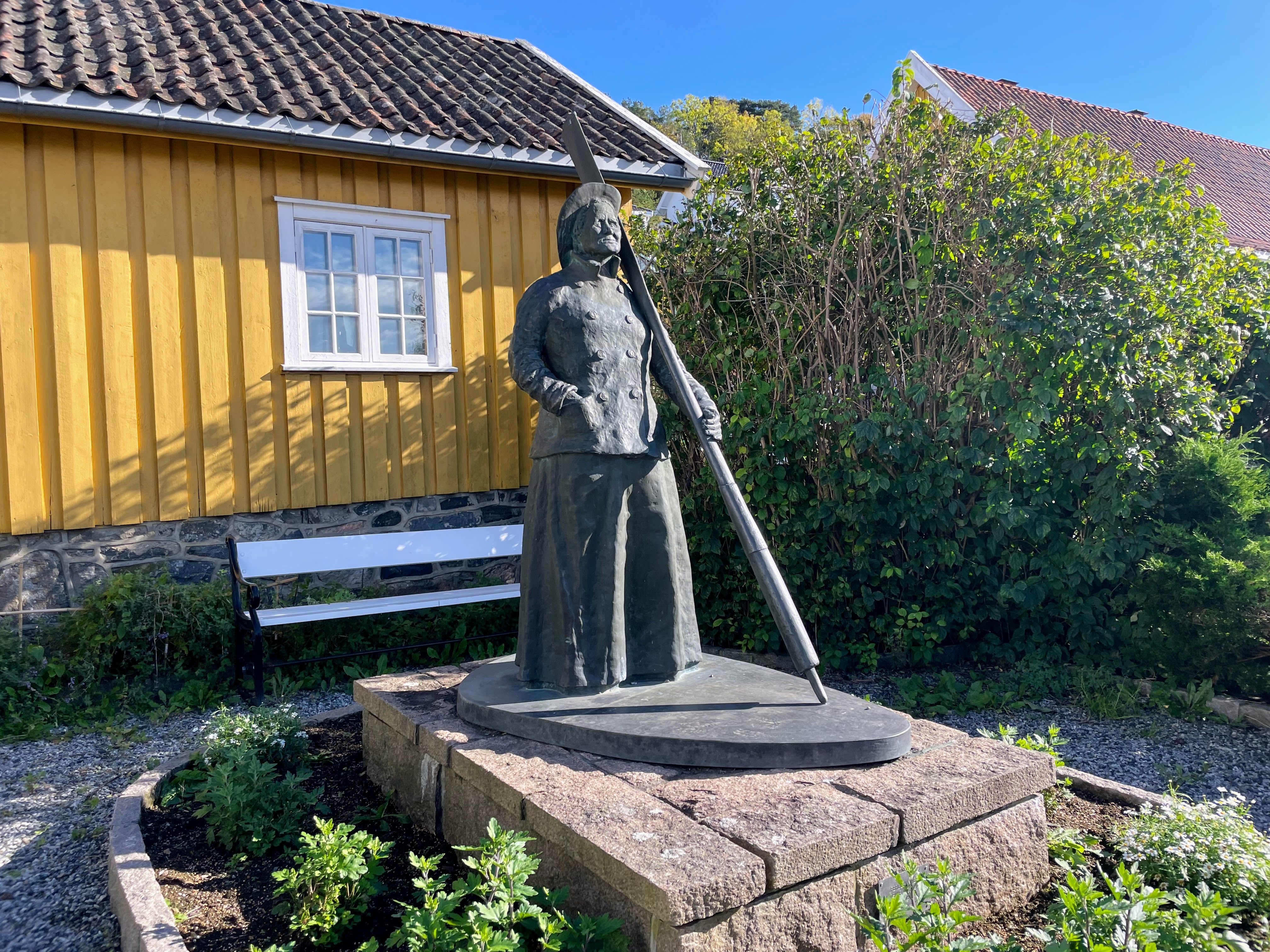 Jakobine statue in bronze in front of yellow house