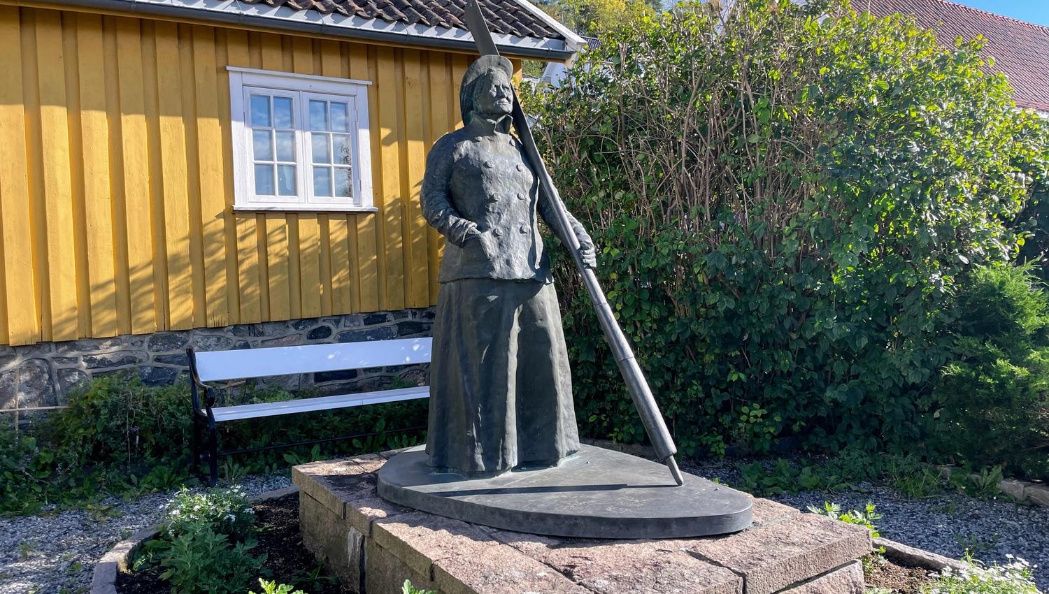 Jakobine statue in bronze in front of yellow house