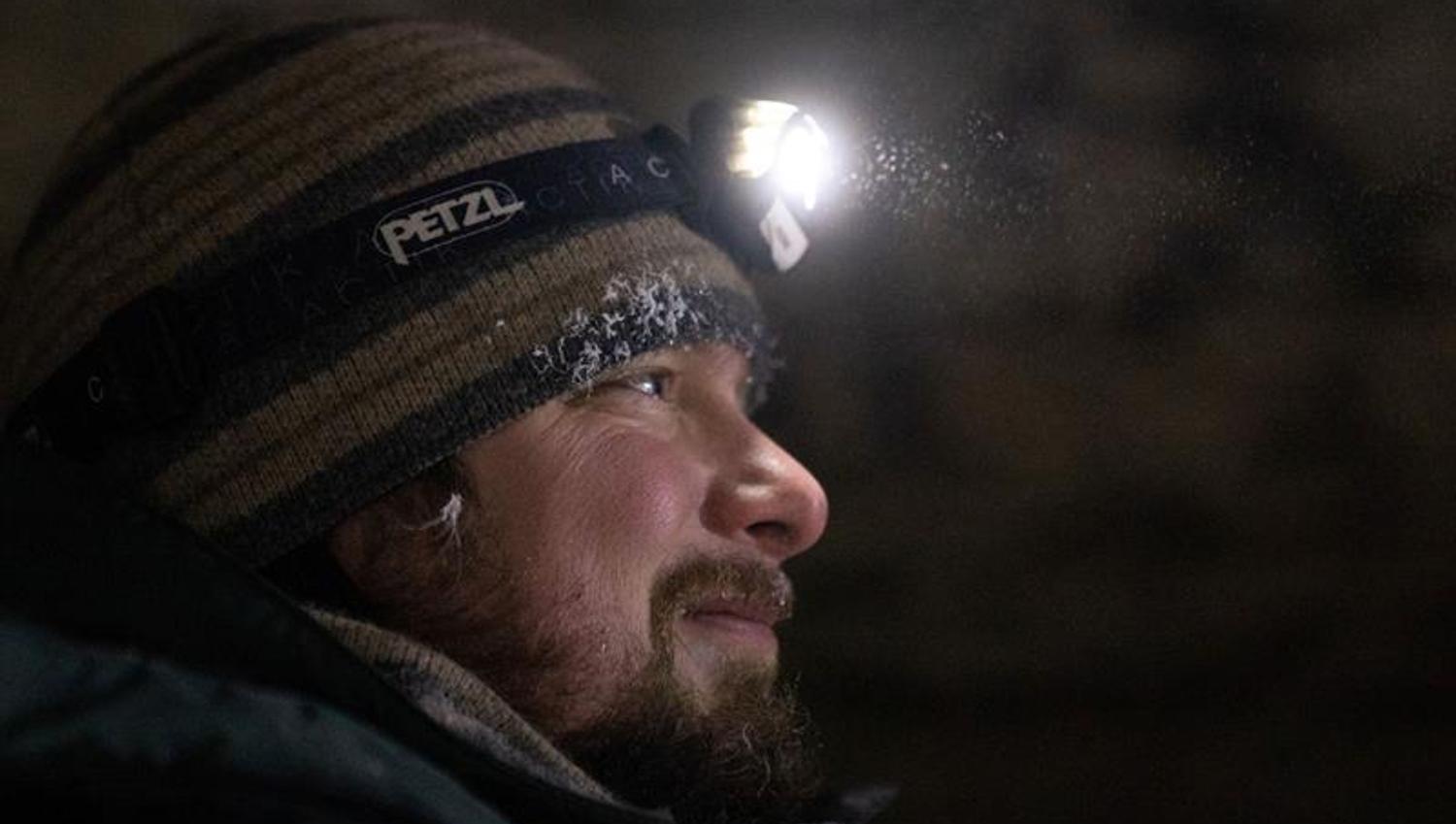 Portrait of a man with head lamp