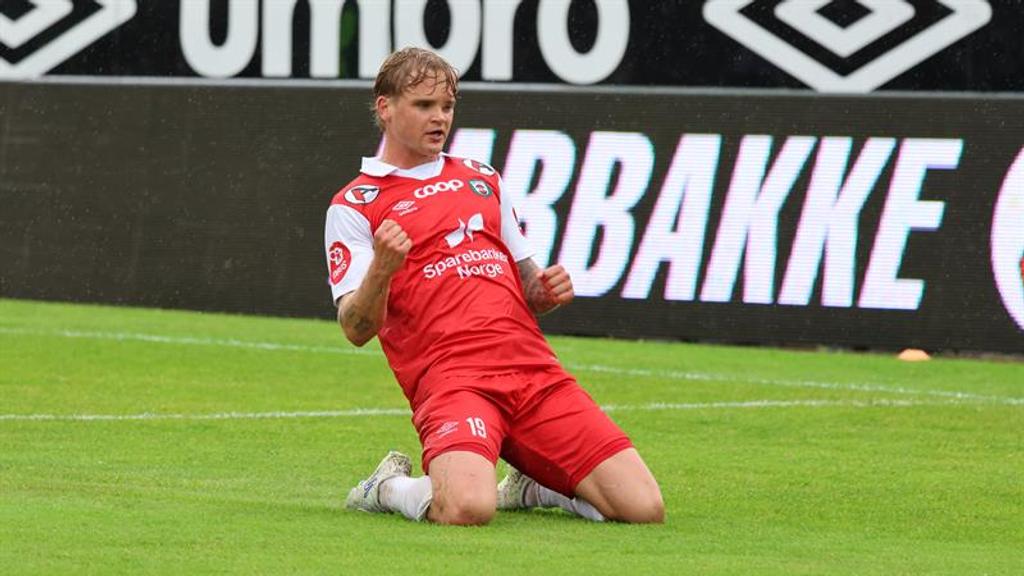 Fotballspiller står på kne på fotballbane