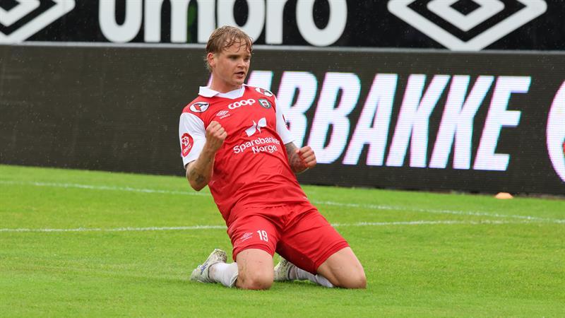 Fotballspiller står på kne på fotballbane