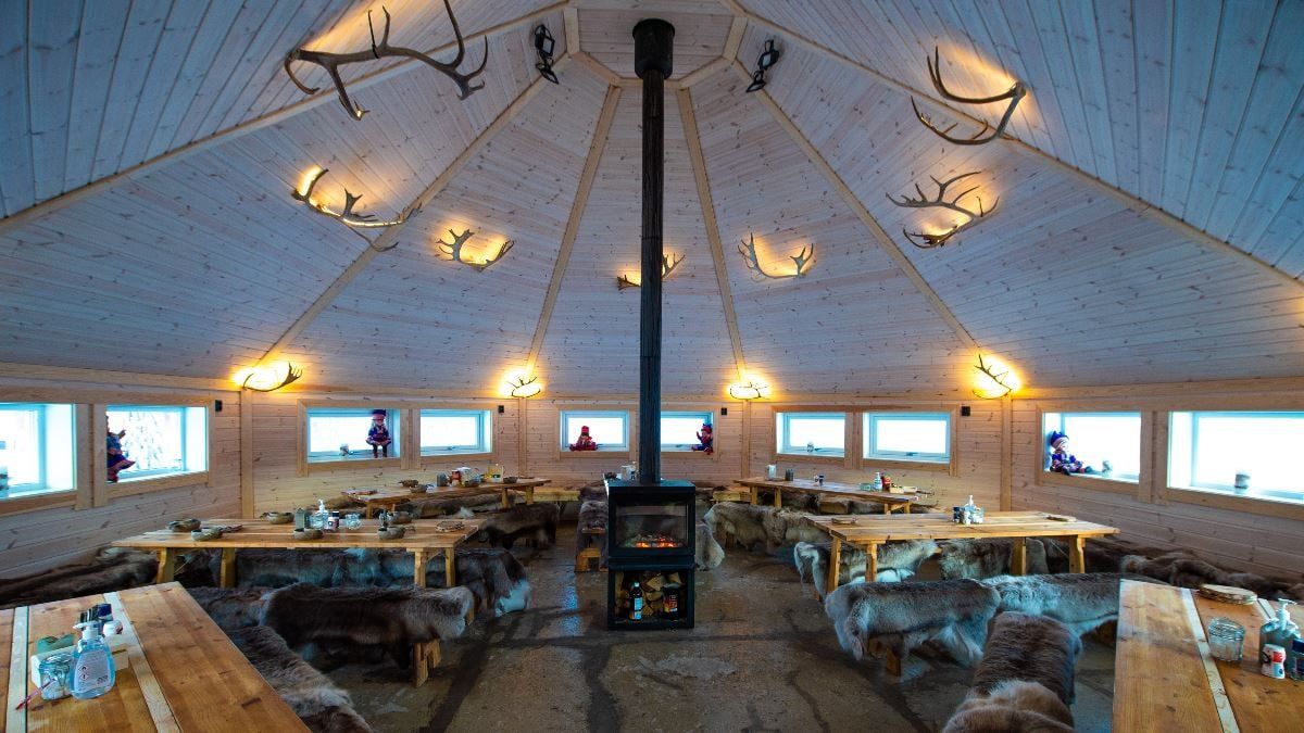 Traditional Sámi lavvu with a fireplace and seating at Tromsø Lapland’s camp near Tromsø.