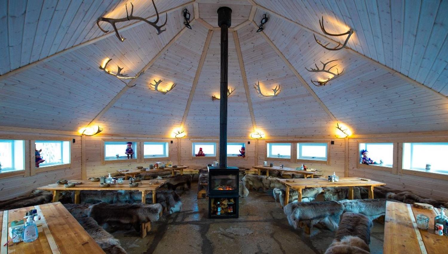Traditional Sámi lavvu with a fireplace and seating at Tromsø Lapland’s camp near Tromsø.