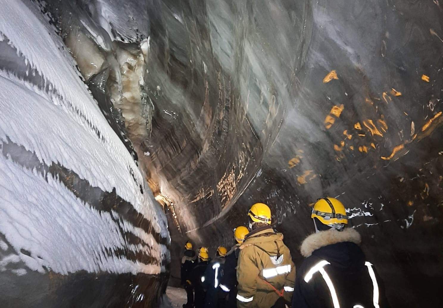 A group of persons inside an ice cave