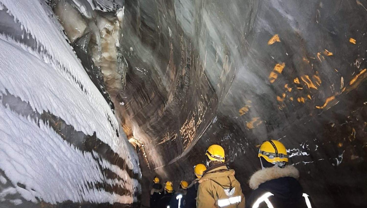 A group of persons inside an ice cave