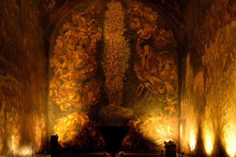 From the exhibition. Wall and ceiling paintings illuminated in dim lighting.