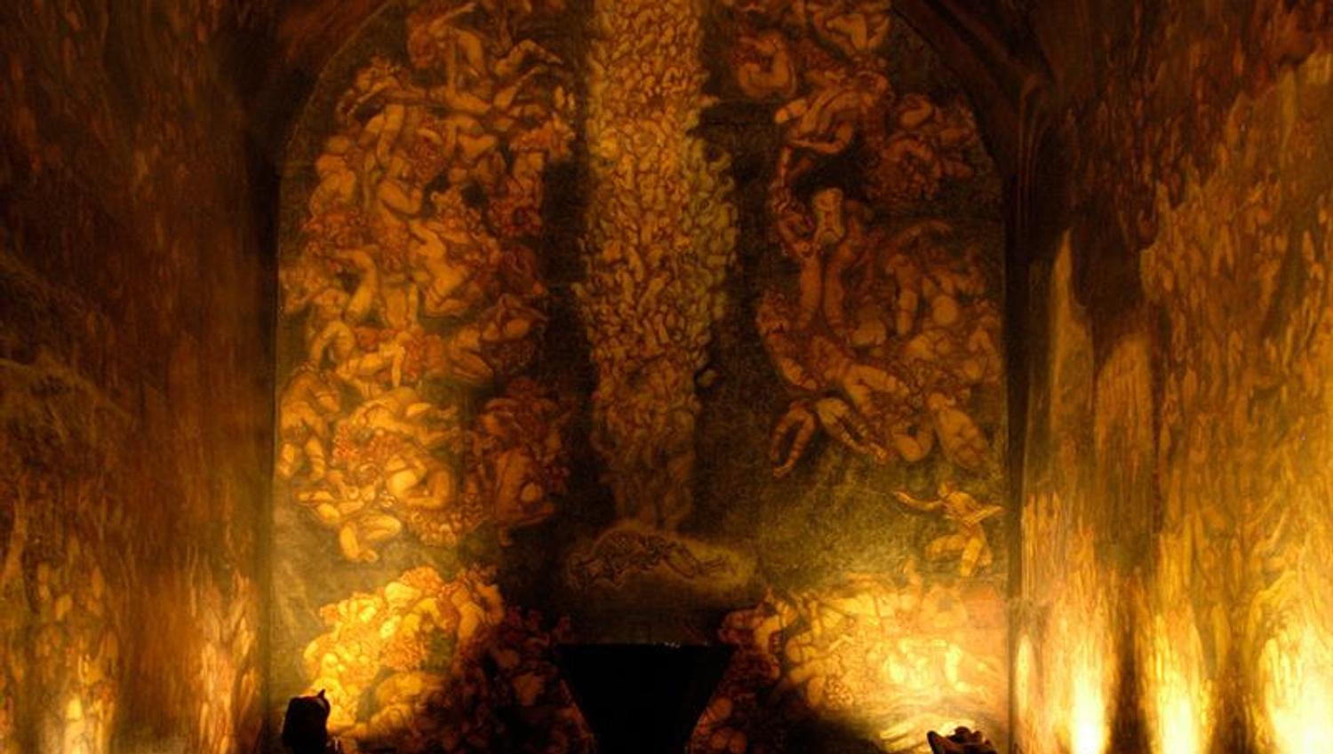From the exhibition. Wall and ceiling paintings illuminated in dim lighting.