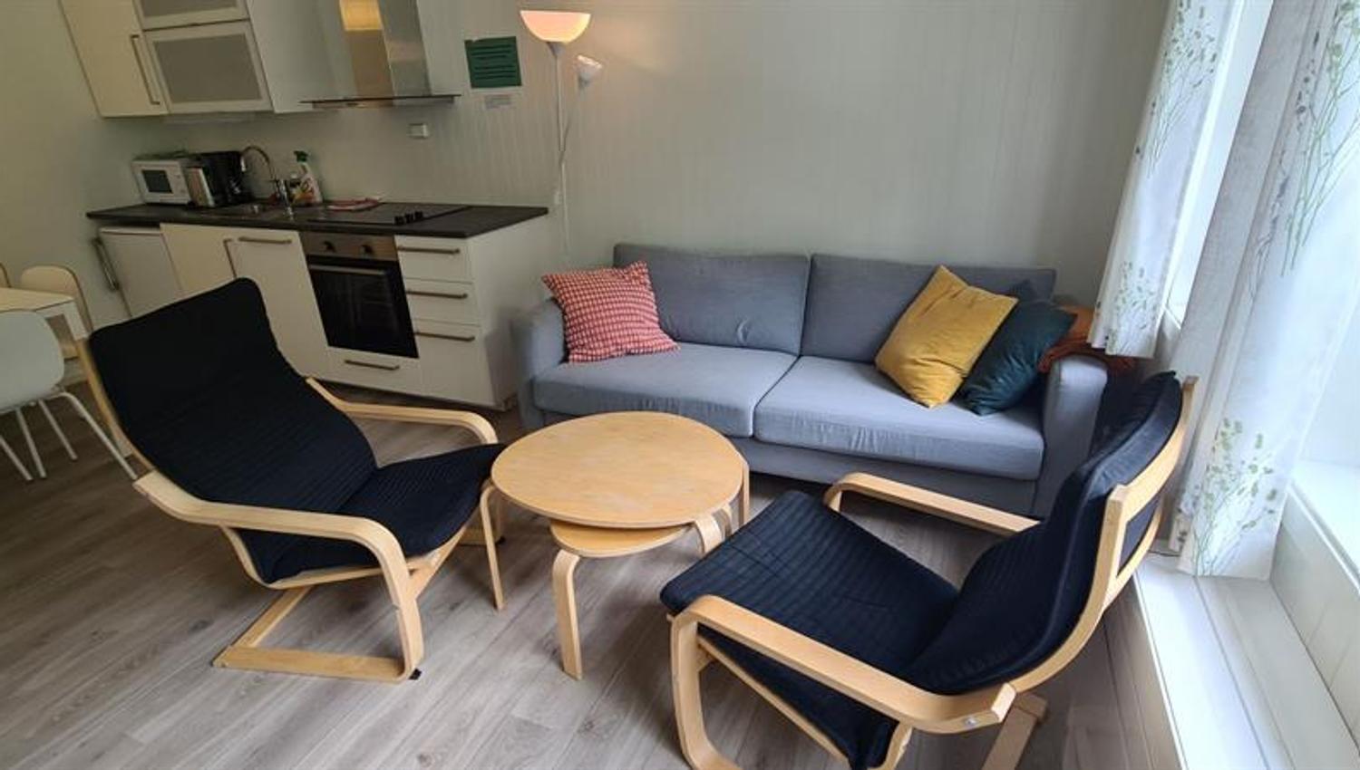 Living room and kitchenette in a cabin at Trolltunga Camping with seating area and bright details.