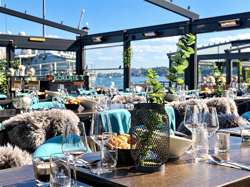 Outdoor seating at Kokeriet Restaurant in Sandefjord with set tables by the waterfront.