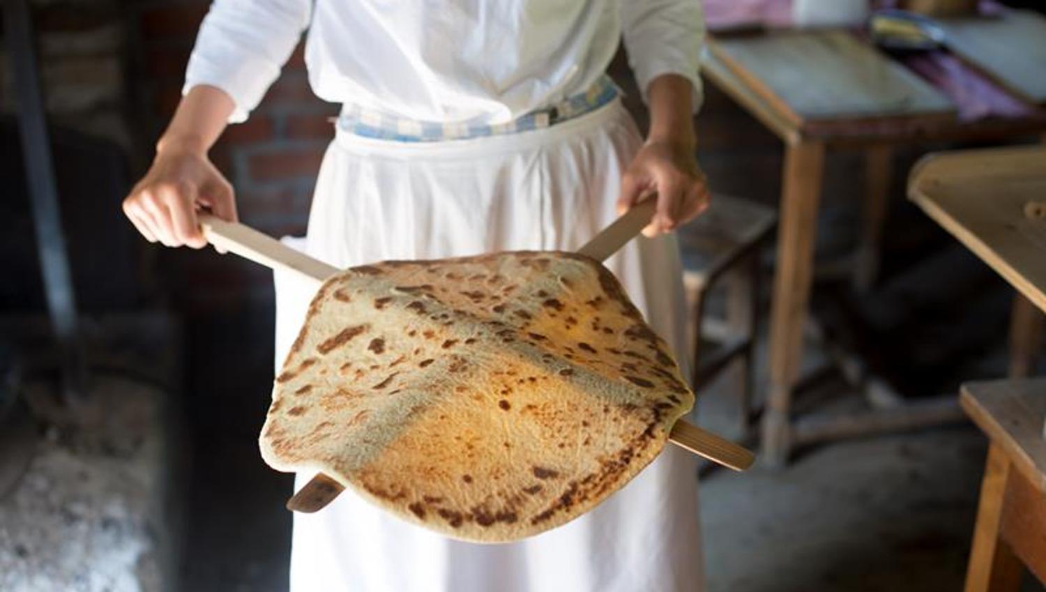 Newly baked pancake on wooden sticks. Norwegian Museum of Cultural History