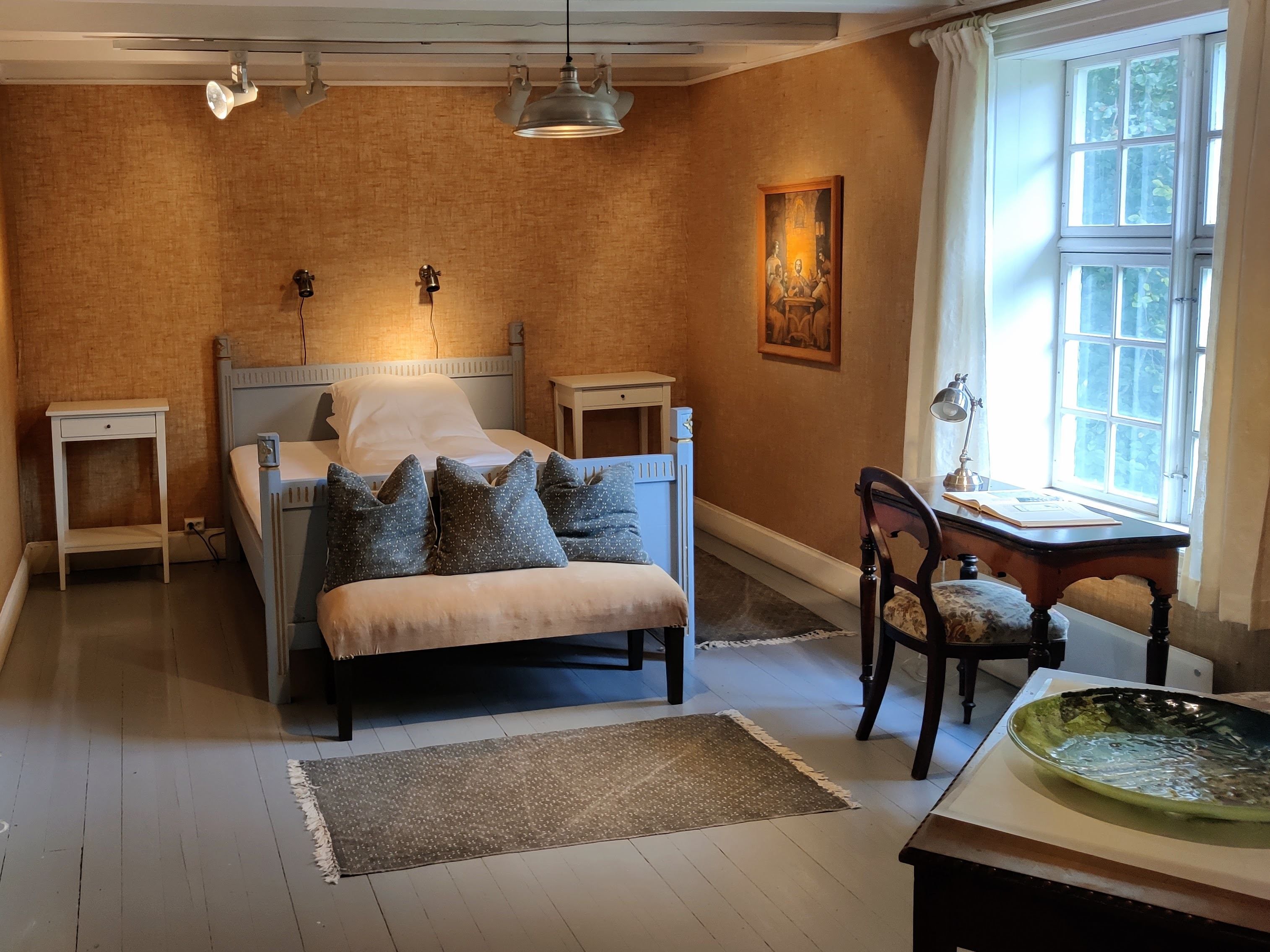 One of the individually furnished bedrooms at Skrivergaarden, with classic furniture and a historic atmosphere.