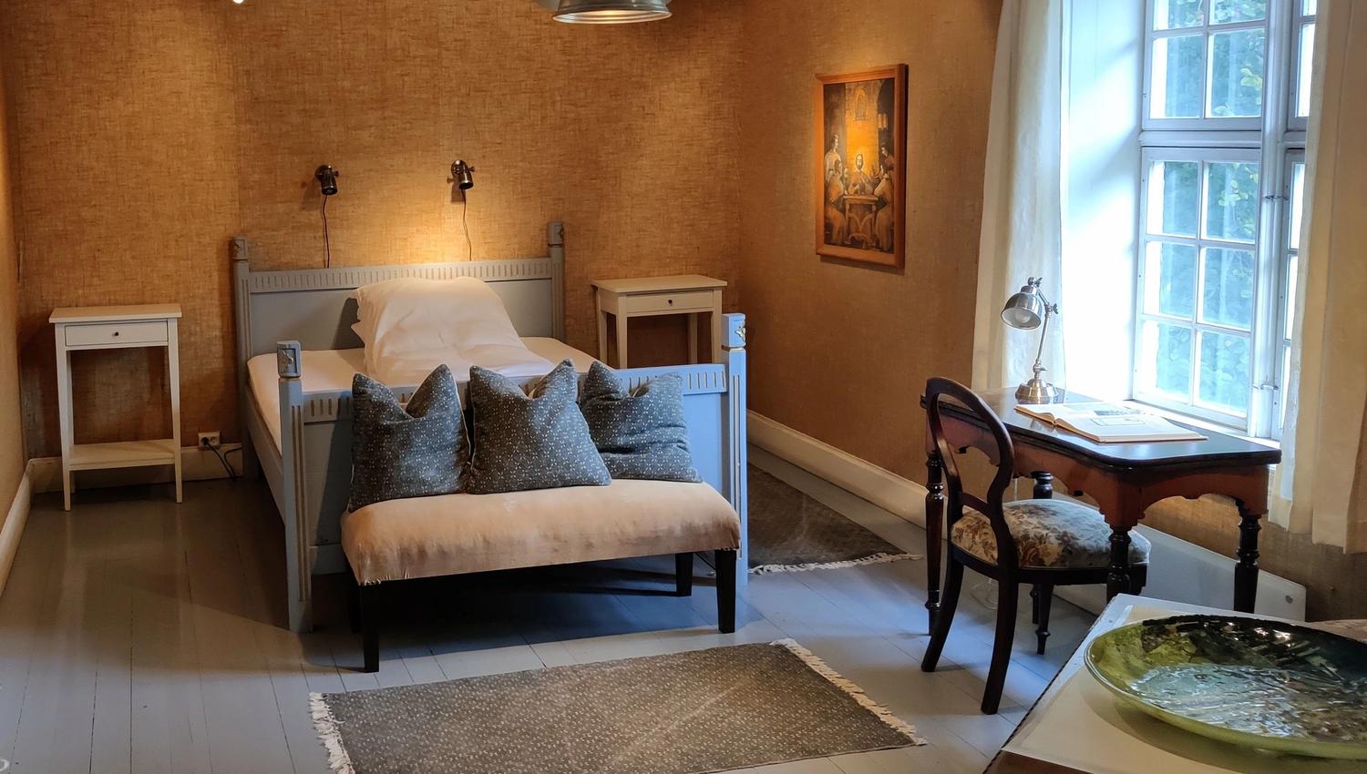 One of the individually furnished bedrooms at Skrivergaarden, with classic furniture and a historic atmosphere.