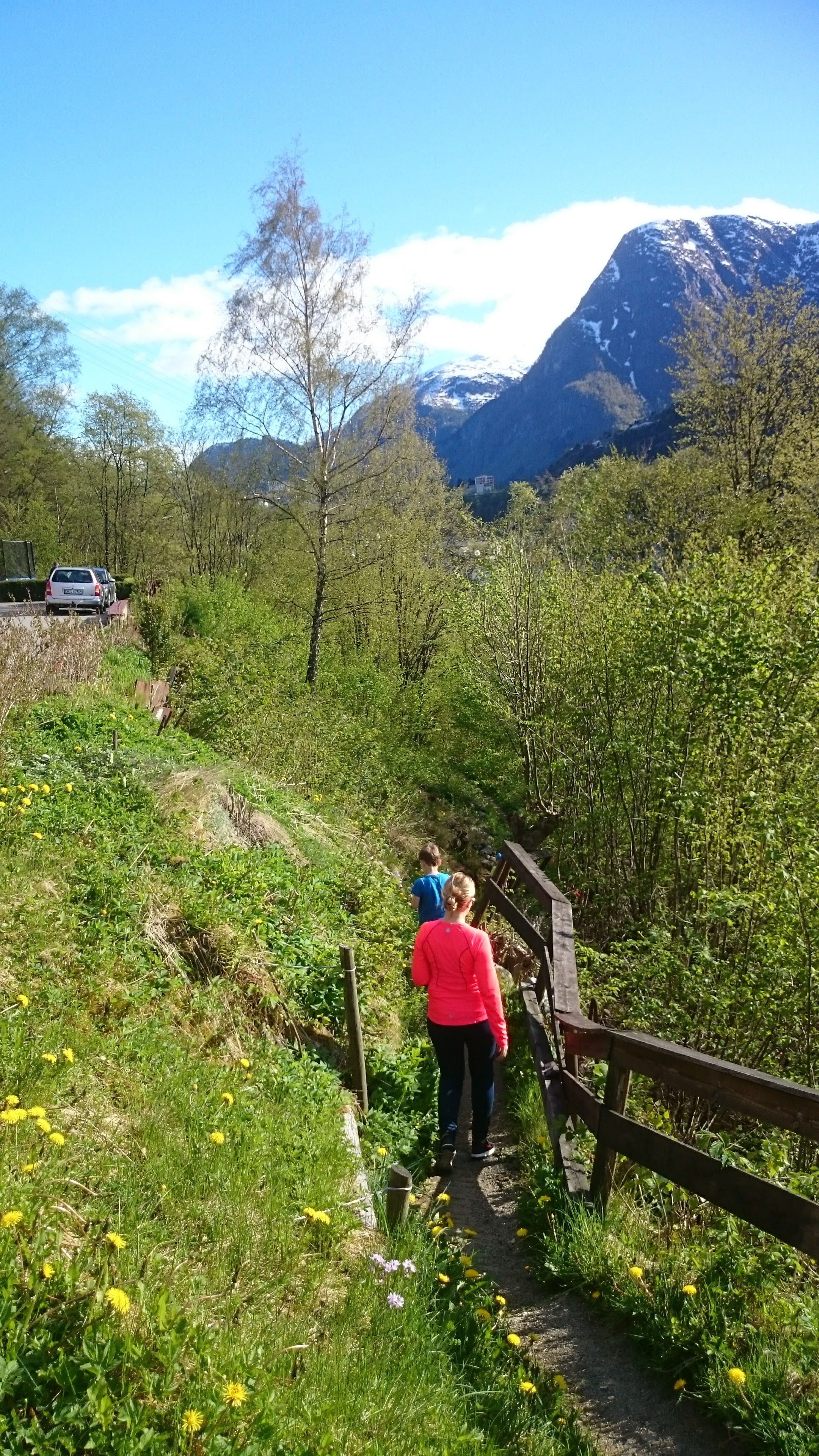 A family walking along the Hjøllo–Mannsåker cultural trail in Hardanger on a sunny spring day.