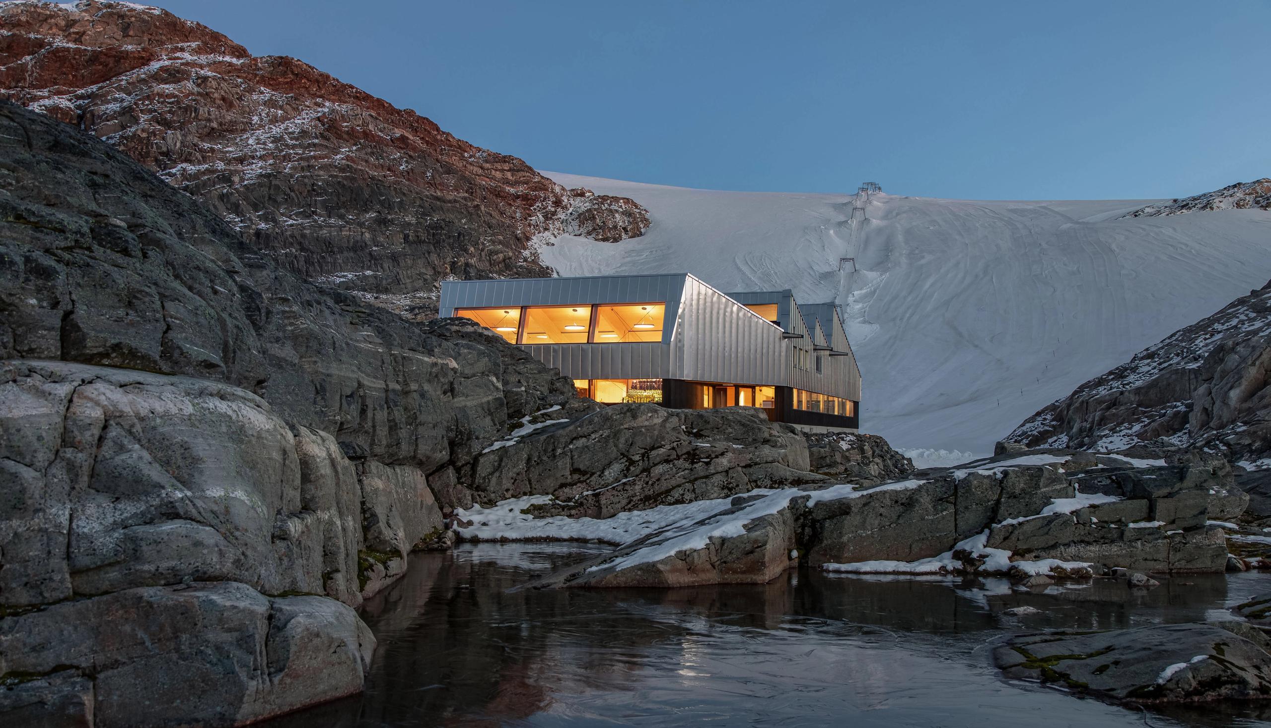 Moderne arkitektur ved Fonna1199 med isbreen Folgefonna i bakgrunnen, midt i Hardanger sitt majestetiske landskap.