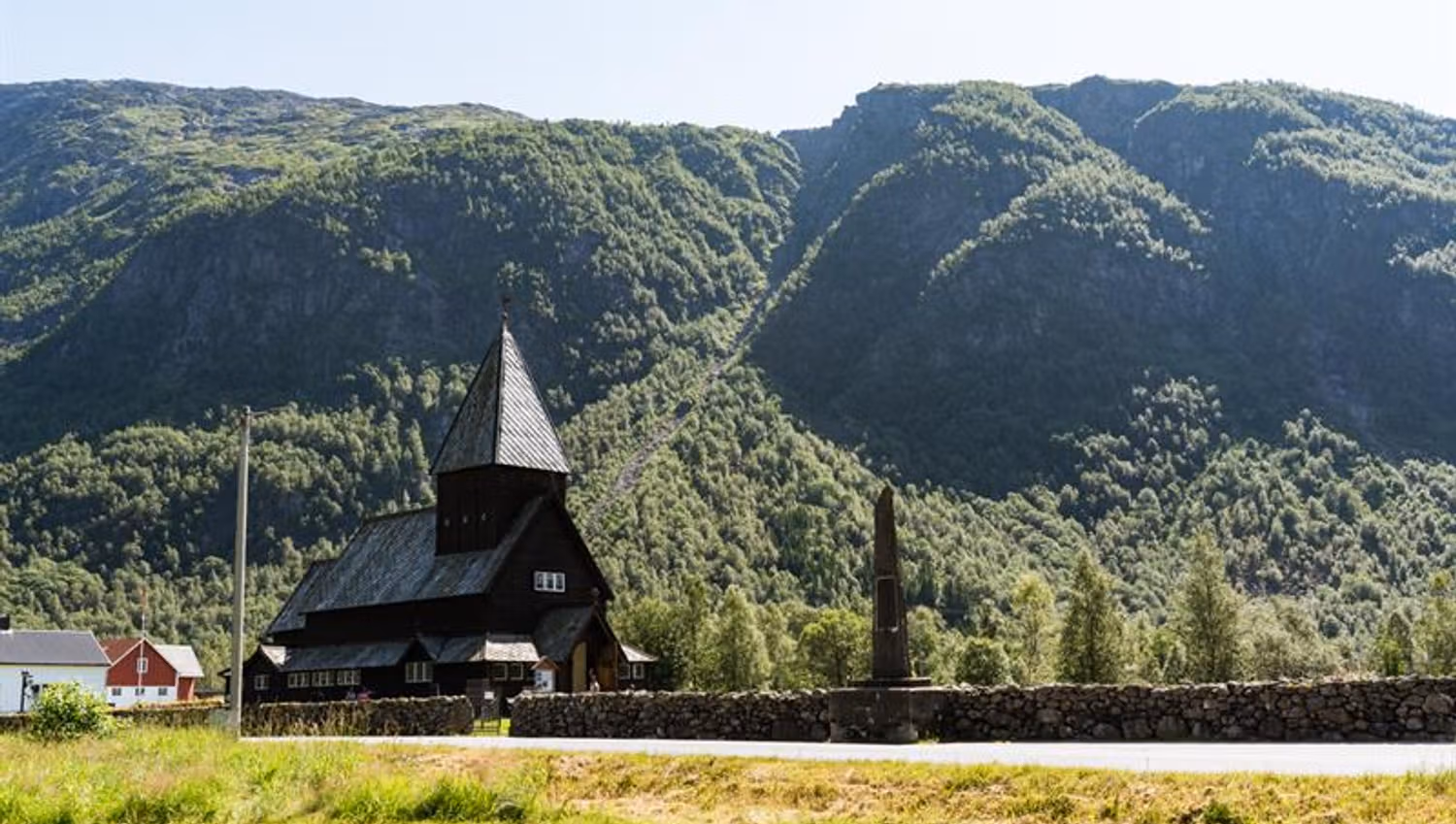 Røldal Stave Church surrounded by majestic mountains in Hardanger, a medieval cultural landmark.