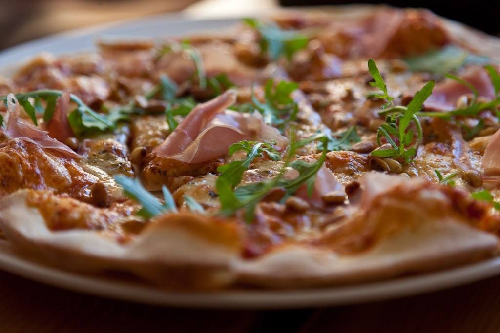 Stone oven-baked pizza from Restaurant Meieriet at Kramsjø Guesthouse, made with fresh local ingredients.