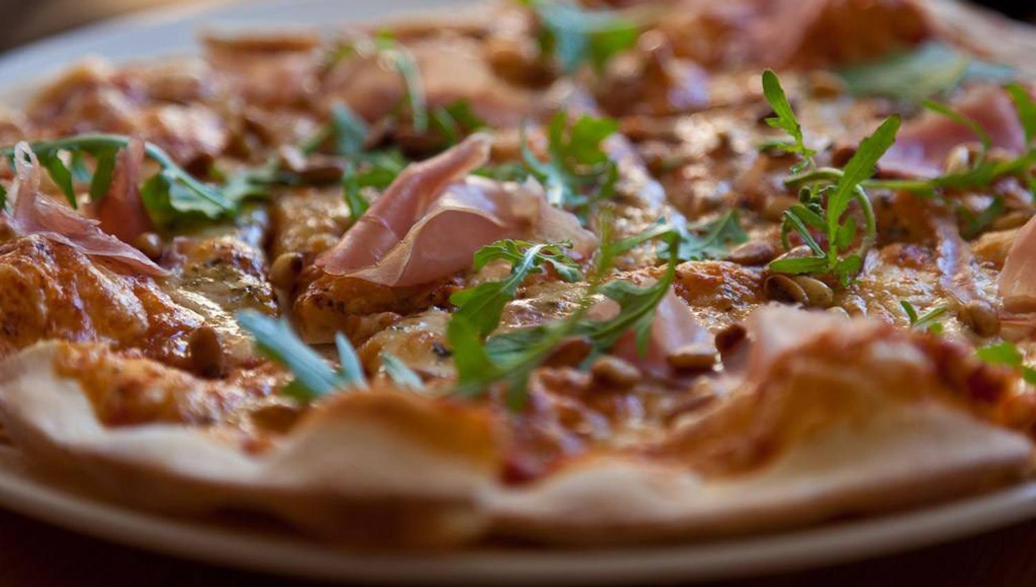 Stone oven-baked pizza from Restaurant Meieriet at Kramsjø Guesthouse, made with fresh local ingredients.