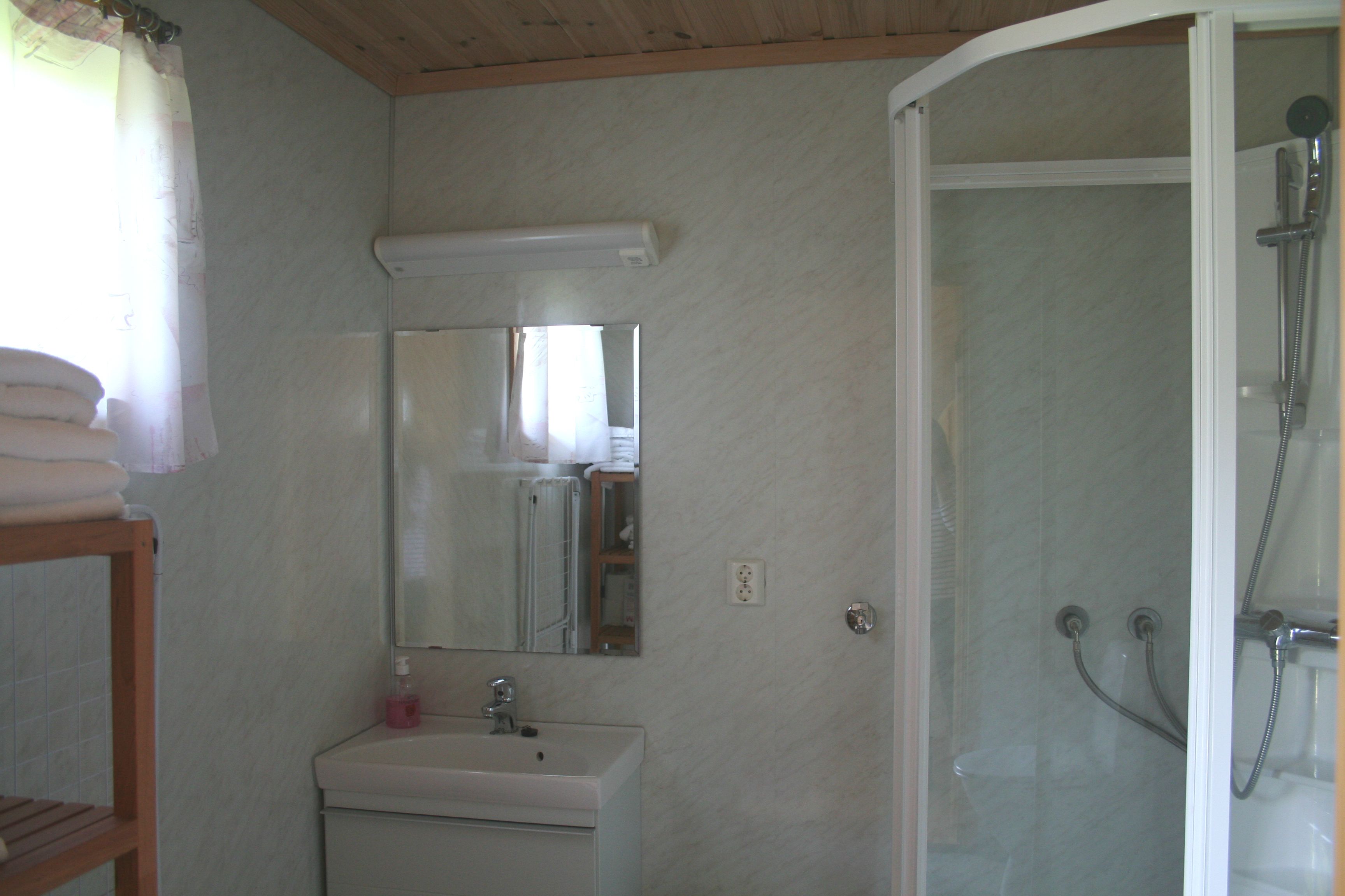 Clean and modern bathroom with shower and sink in a cabin at Oddland Camping.