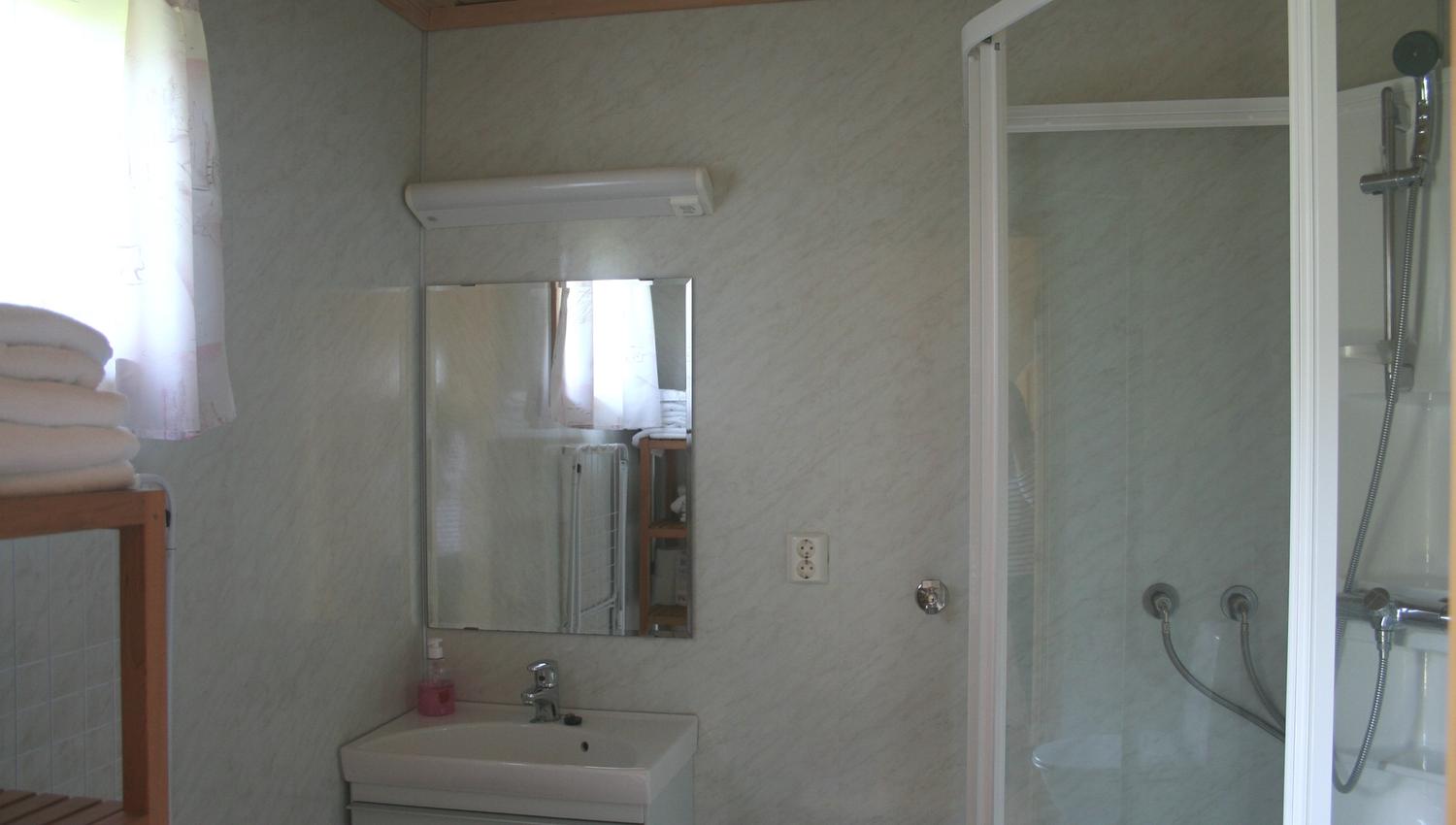 Clean and modern bathroom with shower and sink in a cabin at Oddland Camping.
